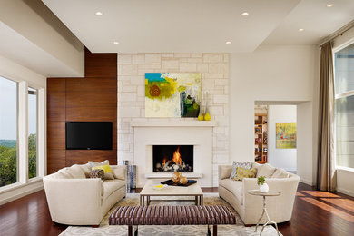 Example of a large trendy living room design in Austin with a standard fireplace and a wall-mounted tv