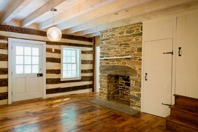 Example of a mid-sized cottage formal and enclosed medium tone wood floor living room design in Baltimore with white walls, a standard fireplace and a stone fireplace