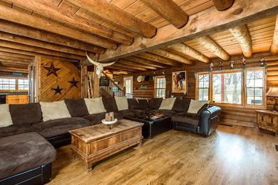 Ispirazione per un soggiorno rustico con pavimento in legno massello medio