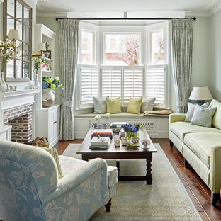 Design ideas for a medium sized traditional formal enclosed living room in London with blue walls, dark hardwood flooring, a standard fireplace, a brick fireplace surround, brown floors and feature lighting.