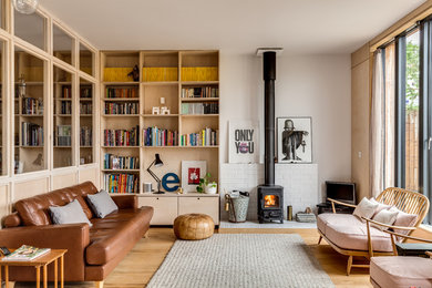 Photo of a medium sized scandi open plan living room in London with white walls, light hardwood flooring and a wood burning stove.