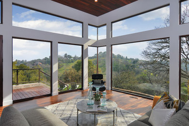 Example of a mid-sized minimalist formal and open concept dark wood floor and brown floor living room design in San Francisco with white walls, no fireplace and a concealed tv