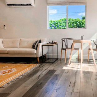 Ispirazione per un piccolo soggiorno nordico aperto con sala formale, nessun camino, pavimento marrone, pareti beige, pavimento in laminato e TV autoportante