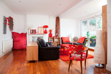 Fernseherloses, Offenes Modernes Wohnzimmer ohne Kamin mit weißer Wandfarbe und braunem Holzboden in London