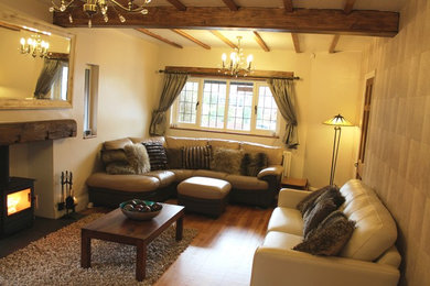 Inspiration for a contemporary living room in West Midlands with a wood burning stove and a wooden fireplace surround.