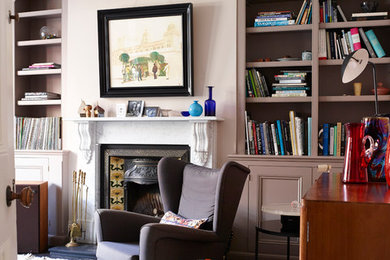 Источник вдохновения для домашнего уюта: изолированная гостиная комната среднего размера в стиле ретро с бежевыми стенами, деревянным полом, стандартным камином, фасадом камина из камня и черным полом без телевизора