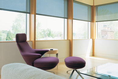 Modelo de salón abierto actual de tamaño medio sin chimenea y televisor con paredes beige y suelo de madera clara