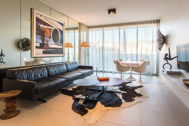 Modelo de salón para visitas abierto contemporáneo de tamaño medio con paredes blancas, suelo de baldosas de cerámica, televisor colgado en la pared y suelo beige