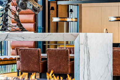 ブリスベンにあるラグジュアリーな巨大なコンテンポラリースタイルのおしゃれなリビング (淡色無垢フローリング、両方向型暖炉、石材の暖炉まわり) の写真