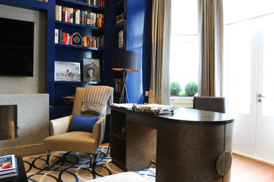 This is an example of a small contemporary formal enclosed living room in London with blue walls, medium hardwood flooring, a standard fireplace, a stone fireplace surround and a wall mounted tv.