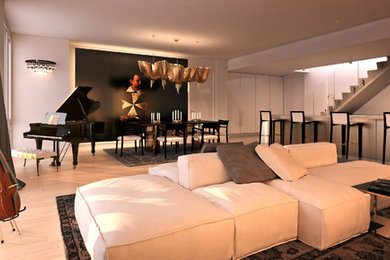 Aménagement d'un grand salon contemporain ouvert avec un mur blanc et parquet clair.