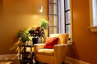 Ejemplo de biblioteca en casa tipo loft romántica pequeña con paredes beige, suelo de madera clara y televisor colgado en la pared