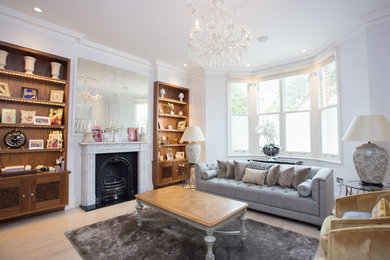 Photo of a large contemporary open plan living room in London with white walls, light hardwood flooring, a wood burning stove and a stone fireplace surround.
