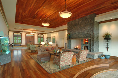 ハワイにある高級な広いコンテンポラリースタイルのおしゃれなリビング (石材の暖炉まわり、白い壁、無垢フローリング、標準型暖炉、テレビなし、茶色い床) の写真