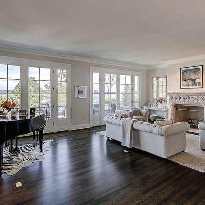 Inspiration for a large transitional enclosed dark wood floor living room remodel in Seattle with a music area, beige walls, a standard fireplace, a plaster fireplace and no tv