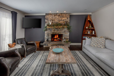 Example of an open concept brown floor living room design in Toronto with gray walls, a standard fireplace, a stone fireplace and a wall-mounted tv