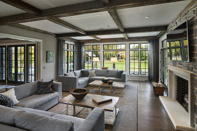 Inspiration pour un grand salon traditionnel ouvert avec un mur gris, parquet foncé, une cheminée standard, un manteau de cheminée en pierre et un téléviseur fixé au mur.