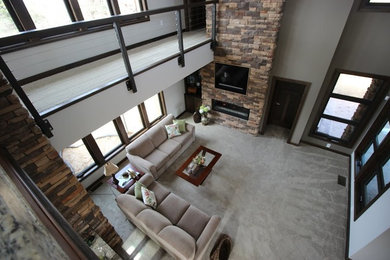 Imagen de salón actual de tamaño medio con todas las chimeneas, marco de chimenea de piedra y pared multimedia