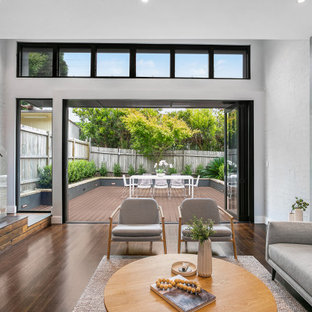 Photo of a large contemporary open concept living room in Sydney with white walls, medium hardwood floors and brown floor.