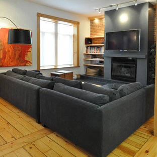 Idee per un soggiorno contemporaneo con pavimento in legno massello medio, TV a parete e pavimento giallo