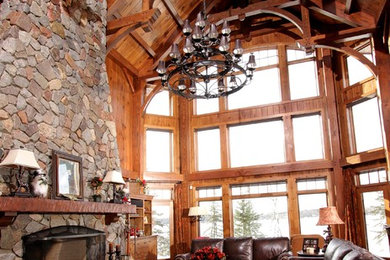 Inspiration for a large rustic formal and open concept medium tone wood floor and brown floor living room remodel in Other with a standard fireplace, a stone fireplace and no tv