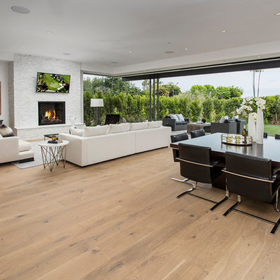 Living room - large 1960s open concept medium tone wood floor and brown floor living room idea in Orange County with white walls, a standard fireplace, a brick fireplace and a wall-mounted tv
