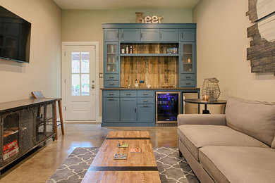 Mittelgroßes, Abgetrenntes Rustikales Wohnzimmer mit Hausbar, beiger Wandfarbe, Betonboden und TV-Wand in Austin