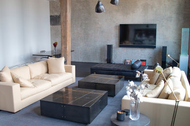 Modelo de salón actual con paredes grises, televisor colgado en la pared y suelo negro