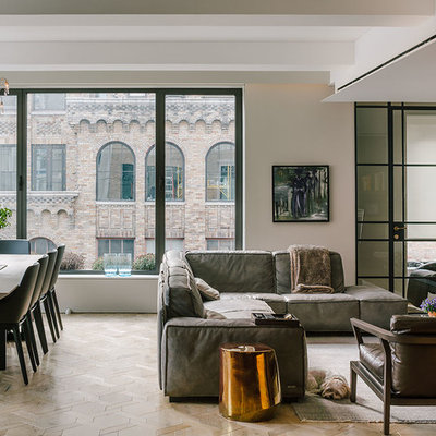Example of a large trendy open concept and formal light wood floor and beige floor living room design in New York with gray walls, no fireplace and a wall-mounted tv