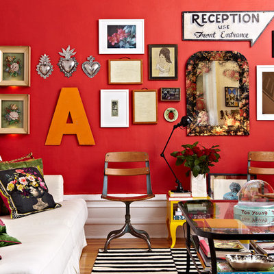 Eclectic medium tone wood floor living room photo in New York with red walls
