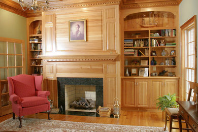 Living room library - mid-sized traditional enclosed medium tone wood floor and brown floor living room library idea in Richmond with green walls, a standard fireplace, a wood fireplace surround and no tv