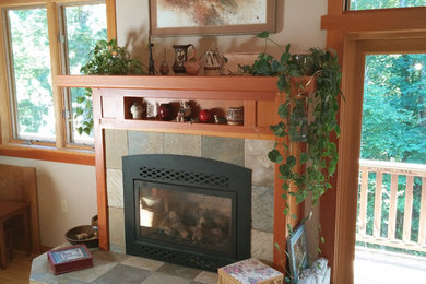 シアトルにあるお手頃価格の中くらいなトラディショナルスタイルのおしゃれなLDK (ベージュの壁、淡色無垢フローリング、標準型暖炉、石材の暖炉まわり) の写真