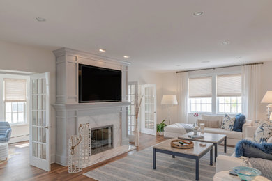 Large beach style formal and enclosed vinyl floor and brown floor living room photo in Philadelphia with white walls, a standard fireplace, a wood fireplace surround and a media wall