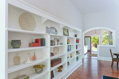 Traditional living room in Santa Barbara with white walls, medium hardwood flooring and brown floors.