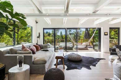 Immagine di un soggiorno minimal aperto con pareti bianche, parquet chiaro e pavimento beige