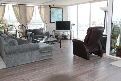 Example of a 1960s light wood floor living room design in San Diego with a tv stand