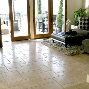 Immagine di un grande soggiorno classico aperto con sala formale, pareti beige, pavimento in travertino, camino classico, cornice del camino in pietra e TV a parete