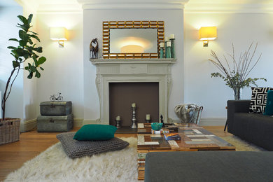 Foto de salón abierto bohemio con paredes blancas, suelo de madera en tonos medios, todas las chimeneas, marco de chimenea de madera y televisor independiente
