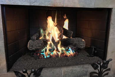 シカゴにある中くらいなトラディショナルスタイルのおしゃれな独立型リビング (標準型暖炉、石材の暖炉まわり、磁器タイルの床、テレビなし、グレーの床) の写真