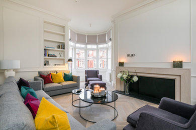 This is an example of a large contemporary formal open plan living room in London with white walls, light hardwood flooring, a standard fireplace, a stone fireplace surround and beige floors.