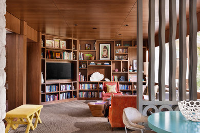 Example of a large 1960s open concept living room library design in Austin