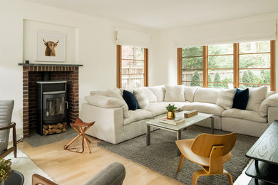 Photo of a classic living room in Minneapolis with white walls, light hardwood flooring and a wood burning stove.