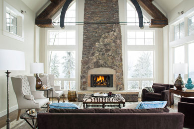 デンバーにある高級な巨大なラスティックスタイルのおしゃれなLDK (白い壁、無垢フローリング、標準型暖炉、石材の暖炉まわり、テレビなし) の写真