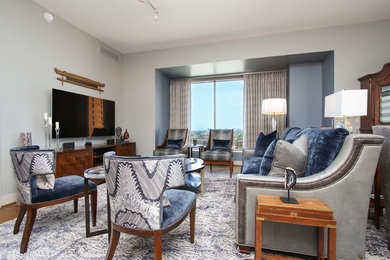 Example of a small transitional open concept medium tone wood floor and brown floor living room design in DC Metro with gray walls, no fireplace and a wall-mounted tv