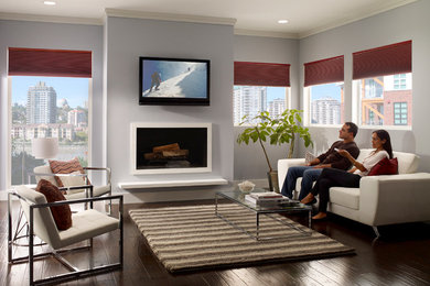 Imagen de salón abierto contemporáneo de tamaño medio con paredes azules, suelo de madera oscura, todas las chimeneas y televisor colgado en la pared