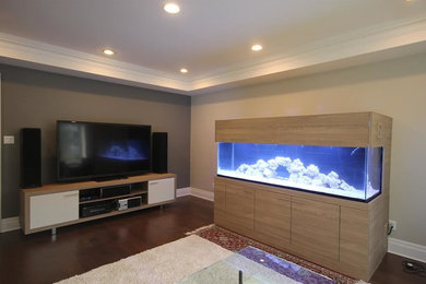 Diseño de salón cerrado actual grande con paredes beige, suelo de madera en tonos medios y televisor independiente