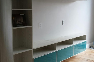 Ejemplo de salón con barra de bar abierto minimalista de tamaño medio con suelo de madera clara, televisor colgado en la pared y suelo marrón