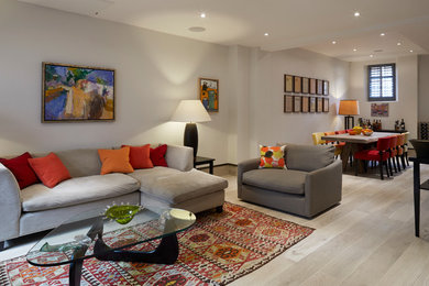 This is an example of a medium sized mediterranean open plan living room in London with beige walls, light hardwood flooring and beige floors.