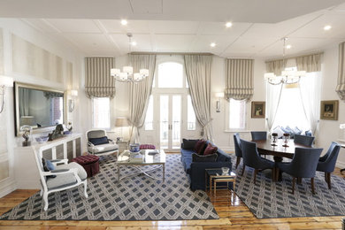 Foto de salón para visitas tipo loft clásico de tamaño medio con paredes blancas, suelo de madera clara y televisor retractable