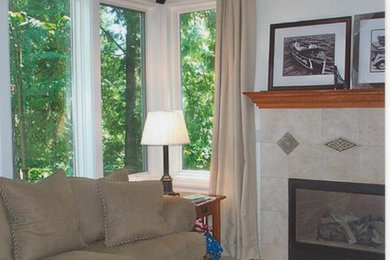 シアトルにある高級な中くらいなトランジショナルスタイルのおしゃれなLDK (ベージュの壁、カーペット敷き、標準型暖炉、タイルの暖炉まわり、据え置き型テレビ) の写真